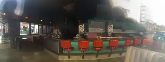 Intérieur d’un café avec comptoir et tabourets.